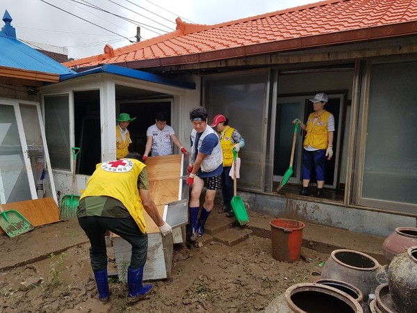 ▲ 18일 폭우로 산사태가 주택을 덮친 청주시 미원면에서 적십자 봉사원들이 가재도구를 꺼내고 있다.ⓒ충북적십자봉사회