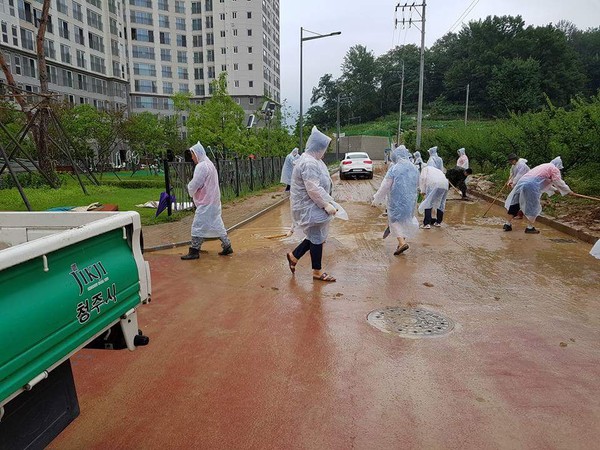 ▲ 자원봉사자들이 집중호우로 산에서 흘러내린 진흙 등을 치우고 있다. ⓒ독자제공