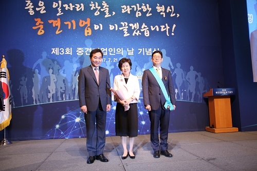 ▲ 금탑산업훈장을 수상한 엄대열 유라코퍼레이션 대표(오른쪽)와 이낙연 국무총리(왼쪽), 가운데는 엄 대표의 어머니 이숙연 여사. ⓒ중기청