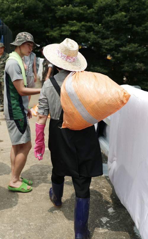 ▲ 21일 오전 김정숙 여사가 충북 청주시 미원면 운암로 청석골마을에서 수해복구작업을 돕기 위해 마대자루를 어께에 메고 이동하고 있다.ⓒ독자제공