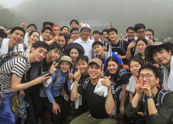 ▲ 박삼구 금호아시아나 회장이 중앙에 희색 티셔츠와 모자를 쓰고 신입사원들과 기념촬영을 하고 있다.ⓒ금호아시아나