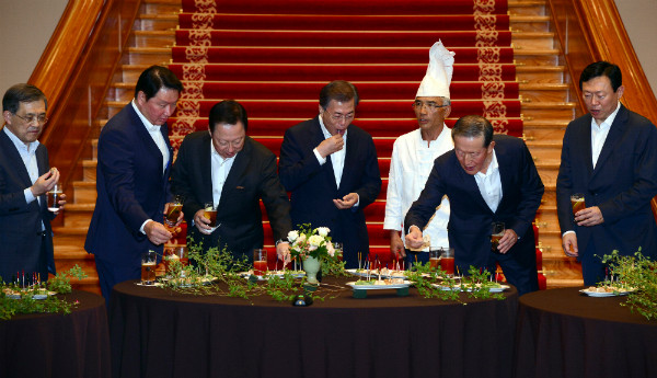 ▲ 문재인 대통령이 28일 청와대 본관 로비에서 경제인들과 만나 칵테일과 함께 안주류의 맛을 보고 있다. 이날 2일차 간담회는 우천 관계로 장소가 옥내로 변경됐다. ⓒ뉴시스 사진DB