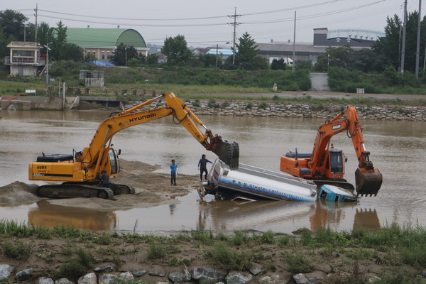 ▲ 지난 16일 충북 청주지역에 300mm의 폭우가 쏟아져 무심천에 빠진 살수차를 굴삭기가 동원돼 건져내고 있다.ⓒ독자제보