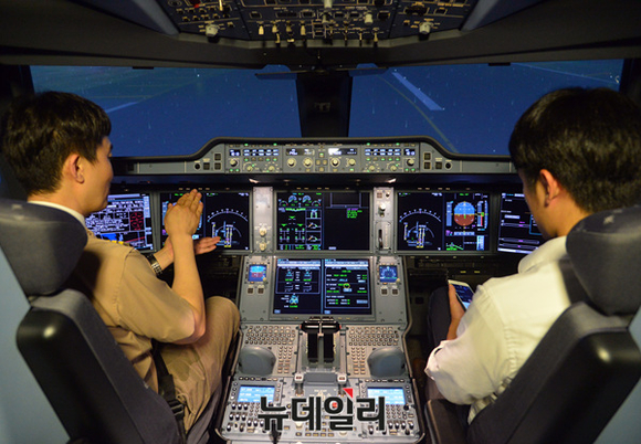 ▲ 아시아나항공 A350 시뮬레이터 내부에서 기자(오른쪽)가 최현욱 기장(왼쪽)의 설명을 듣고 있다.ⓒ공준표 기자