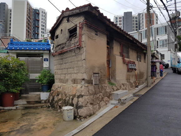 ▲ 서울 창신·숭인 도시재생선도구역 내 개선된 도로포장 옆 방치된 노후 주택. =김백선 기자