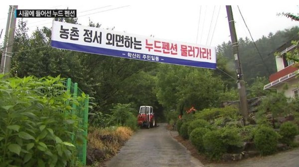 ▲ 조용한 농촌에 ‘누드펜션’이 들어서 지역주민들이 트랙터로 길을 막고 ‘결사반대’ 현수막을 내걸었다.ⓒ독자제공