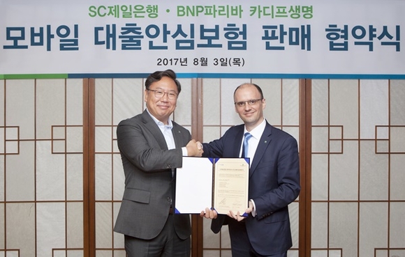 ▲ 지난 3일 서울 종로구에 위치한 SC제일은행 본점에서 윤패트릭 SC제일은행 소매금융총괄본부 부행장(왼쪽)과 브누와 메슬레 BNP파리바 카디프생명 대표이사가 대출상환보장보험(신용생명보험) 업무협약을 체결했다. ⓒSC제일은행