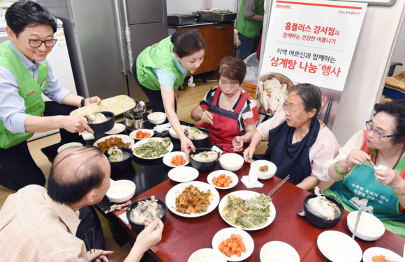 ▲ 홈플러스 강서점 임직원들이 말복을 맞은 11일 서울 강서구 등촌동 노인복지관에서 독거 노인 30여 명을 모시고 삼계탕을 대접하고 있다. ⓒ홈플러스