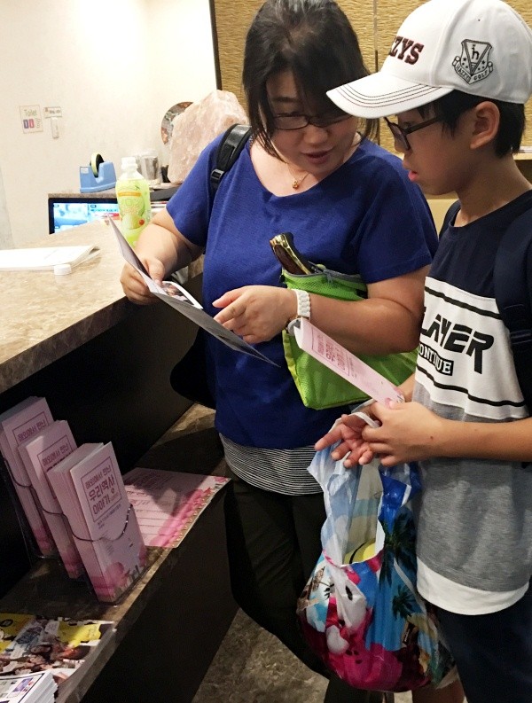 ▲ 민박집에 기증된 안내서를 보고 있는 관광객 모습.