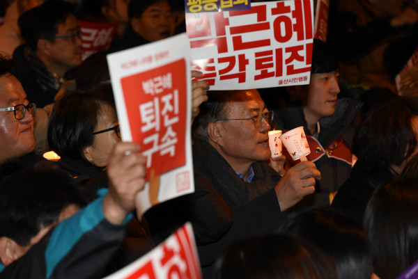 ▲ 문재인 대통령이 지난해 12월 울산광역시에서 촛불을 들고 직전 대통령의 퇴진을 외치고 있다. ⓒ뉴시스 사진DB