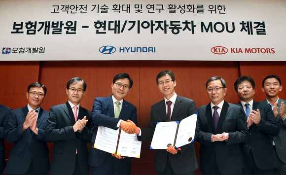 ▲ 현대자동차 고객안전전략사업부 김헌수 부사장(사진 가운데 우측)과 보험개발원 권흥구 부원장(사진 가운데 좌측)이 업무 협약서에 사인한 뒤 악수를 나누고 있다.ⓒ현대자동차그룹