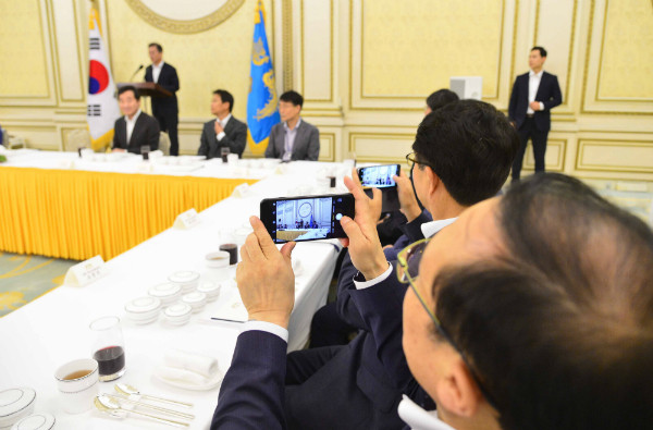 ▲ 북한이 오전에 방사포를 쏘며 서북 5도 점령 훈련을 전개한 26일, 청와대에서 예정대로 더불어민주당 의원단 초청 오찬이 열리고 있다. 이 자리에 참석한 민주당 의원들이 문재인 대통령의 모습을 휴대전화로 촬영하고 있다. ⓒ뉴시스 사진DB
