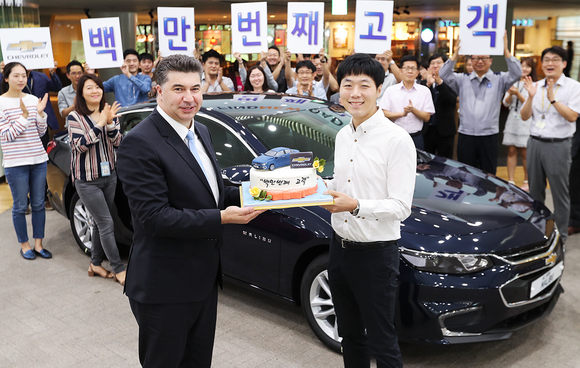▲ 한국지엠 카허 카젬 사장(왼쪽)이 100만 번째 고객으로 선정된 이상범씨(오른쪽)에게 축하 케이크를 전달하고 있는 모습.ⓒ한국지엠
