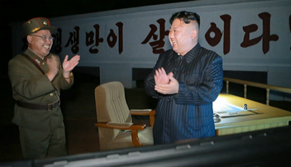 북한 김정은이 탄도미사일 발사 도발을 저지른 뒤, 군 관계자와 함께 손뼉을 치며 자축하고 있다. ⓒ뉴시스 사진DB