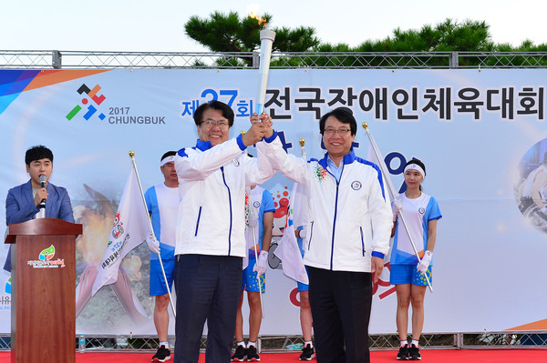 ▲ 이근규 제천시장이 14일 이두표 성화봉송단장이 전달한 성화를 받고 크게 기뻐하고 있다.ⓒ제천시