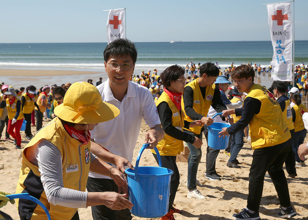 ▲ 안희정 충남지사가 15일 ‘서해안 유류피해 극복 10주년 행사’에 참석해 적십자 봉사자들과 퍼포먼스를 함께하고 있다.ⓒ충남도