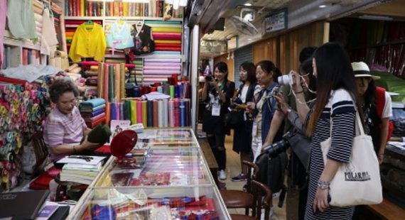 ▲ 중국 파워미디어 취재투어단이 부산 국제시장 한복(주단) 판매점포를 둘러보고 있다. ⓒ소진공