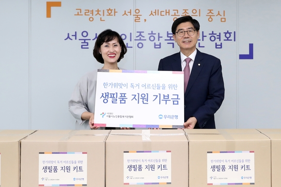 ▲ 성미선 서울시노인종합복지관협회장(왼쪽)과 이광구 우리은행장이 19일 서울 마포구 소재 서울시노인종합복지관협회에서 진행된 한가위 맞이 독거 어르신 사랑나눔 행사에서 기념촬영을 하고 있다.  ⓒ 우리은행