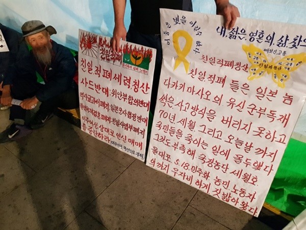 ▲ 23일 오후 7시 광화문 중앙광장에는 백남기투쟁본부 주최로 ‘생명평화 일꾼 백남기 농민 1주기 추모대회’가 열렸다. 한 참석자가 이 추모대회에서 사드반대 등 팻말을 들고 서있다. ⓒ뉴데일리 박진형 기자.