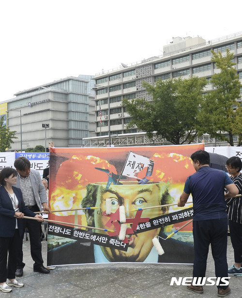 ▲ 27일 오전 서울 광화문광장에서 '전쟁반대평화실현국민행동'이 트럼프 미국 대통령의 얼굴을 롤러로 문지르는 퍼포먼스를 하고 있다. ⓒ사진=뉴시스.