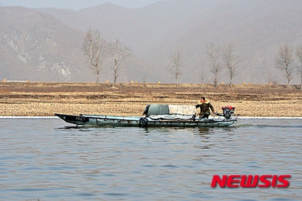 ▲ 북한이 중국의 대북제재 본격화로 외화벌이 타격이 불가피해지자 밀무역에 매달리고 있는 것으로 알려졌다. 사진은중국 랴오닝성 단둥시 외곽 북·중 국경지대 압록강에서 관광객을 상대로 물품을 판매하는 북한 주민이 배를 몰고 이동하고 있는 모습.ⓒ뉴시스. 무단전재 및 재배포 금지