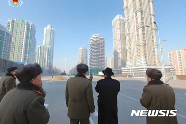 ▲ 지난 4월 평양 여명거리 준공식 전 현장을 둘러본 김정은과 그 일행들. 이런 고층 아파트에 가스와 전기가 들어가지 않는다고 한다. ⓒ뉴시스. 무단전재 및 재배포 금지.