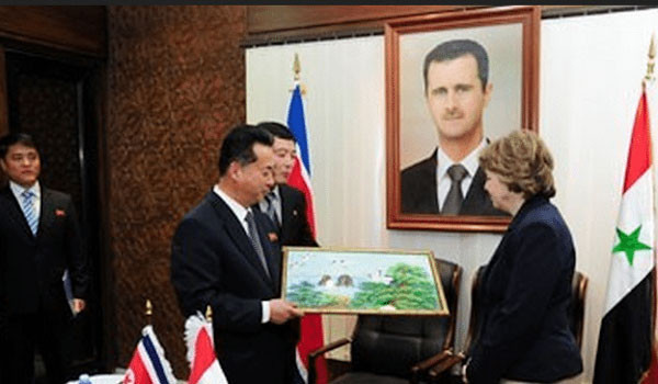 시리아를 찾은 북한 대표단. 뒤로 알 아사드 대통령 초상화가 보인다. ⓒ美NK뉴스 北-시리아 협력 관련보도 화면캡쳐.