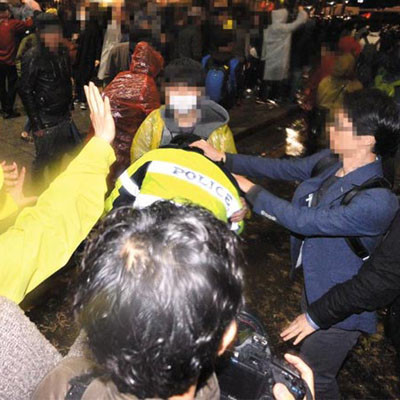 2015년 4월 18일 '세월호 1주기 시위' 중 복면을 쓴 시위대가 경찰 기동대원을 폭행하는 모습. ⓒ뉴시스. 무단전재 및 재배포 금지.