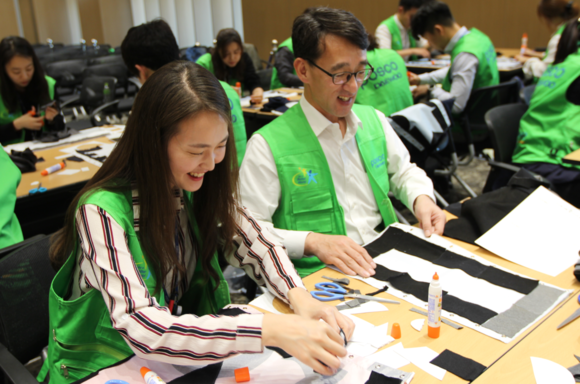 ▲ 포스코대우 임직원 200여 명은지난 20일 인천 송도 사옥에서 사회적기업 터치포굿과 함께 폐현수막을 활용한 나무내복 만들기 봉사활동을 진행했다. ⓒ포스코대우