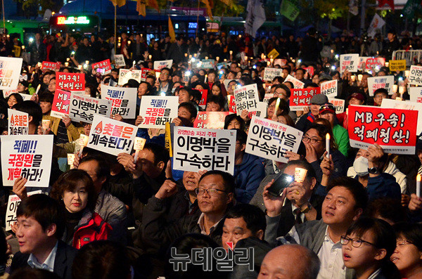 ▲ 28일 저녁 서울 광화문 광장에서 열린 촛불집회 1주년 기념행사에서 집회 참석자들이 과격한 내용이 적힌 팻말을 들고 구호를 외치고 있다. ⓒ뉴데일리 공준표 기자