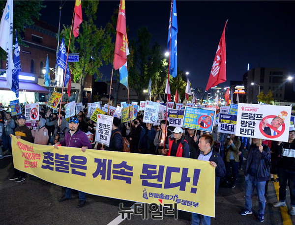 ▲ 촛불집회 1주년 기념행사가 끝난 오후 9시쯤 광화문사거리에서 집회 참석자들이 '촛불은 계속 된다'라고 적힌 포스터를 들고 청와대로 행진하고 있다. ⓒ뉴데일리 공준표 기자