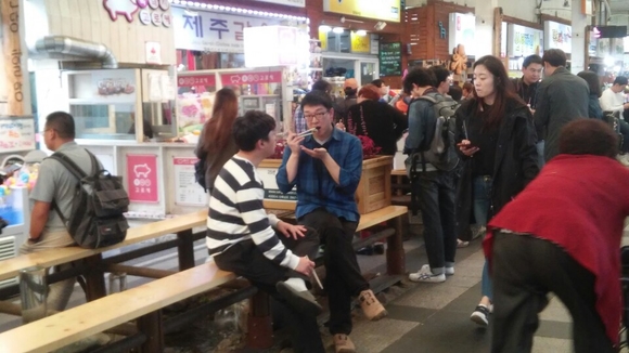 ▲ 매일올레시장 내 모습. 방문객들이 벤치에 앉아 꽁치김밥을 맛있게 먹고 있다. ⓒ뉴데일리DB