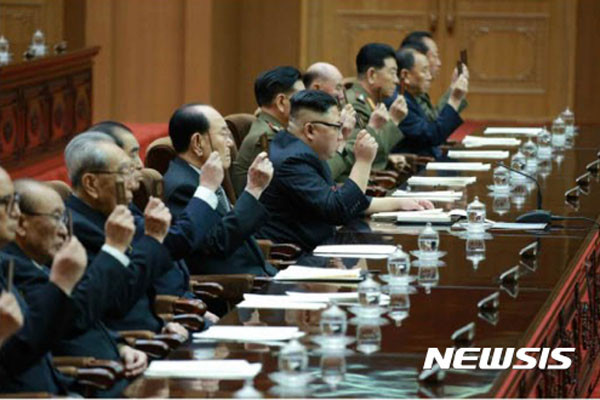 ▲ 김정은과 그 일당들. 당원증을 든 모습이 대북제재에 반대하는 것처럼 보인다. ⓒ뉴시스. 무단전재 및 재배포 금지.