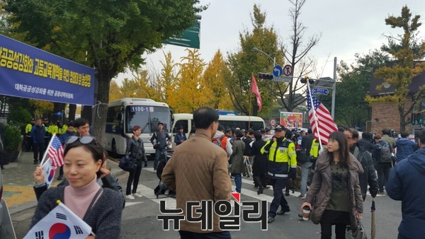 ▲ 7일 오전 11시 서울 종로구 청운동주민센터 앞에서 'NO트럼프 공동행동'이 트럼프 미국 대통령의 방한을 비난하는 기자회견을 열고 있는 가운데, 태극기와 성조기를 든 시민들이 그 앞을 지나가고 있다.ⓒ뉴데일리 임혜진 기자