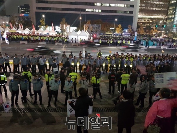 ▲ 이른바 태극기와 촛불 단체들이 세종대로를 사이에 두고 트럼프를 향해 엇갈린 주장을 했다. 태극기 측은 트럼프 방한을 환대한 반면 촛불 측은 원색적인 비난을 가했다.  ⓒ뉴데일리 박진형 기자