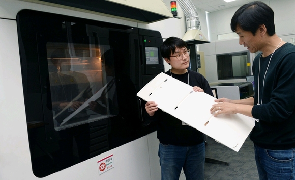 ▲ LG전자 연구원들이 3D프린터로 만들어낸 냉장고 부품을 살펴보고 있다. ⓒLG전자