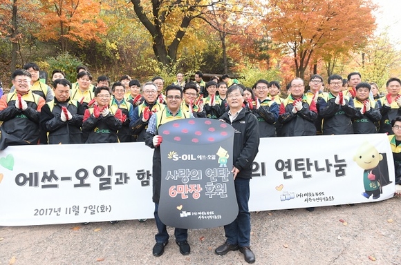 ▲ 오스만 알 감디 CEO (왼쪽)이 따뜻한 한반도 사랑의 연탄나눔운동 본부 이동섭 상임이사(오른쪽)에게 연탄 6만장을 후원하고 임직원 봉사자 100여명과 함께 기념촬영을 하고 있다.ⓒ에쓰-오일