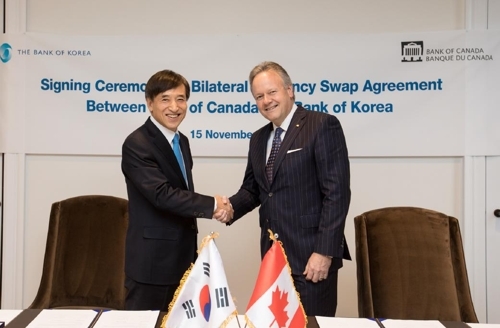 ▲ 5일 오후(현지 시간) 캐나다 오타와에 위치한 캐나다중앙은행 본부에서 이주열(왼쪽) 한국은행 총재가 스티븐 폴로즈 캐나다중앙은행 총재와 양국간 통화스와프 협약서에 서명한 뒤 악수하고 있다. ⓒ 연합뉴스