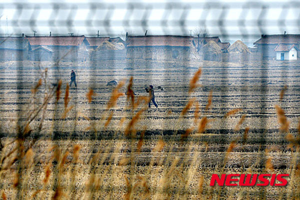 ▲ 철조망 너머로 보이는 북한 농촌. 김정은의 지시에 따라 이제는 농촌이나 광산촌에서 태어난 사람은 평생 그 곳에서 부모와 같은 직업을 갖고 살아야 된다고 한다. ⓒ뉴시스. 무단전재 및 재배포 금지.