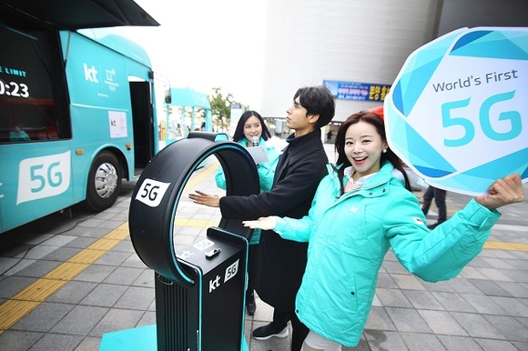 ▲ 관람객이 KT 성화봉송단 ‘KT 챌린저스’와 함께 5G 이동형 홍보관 외부에서 5G 초저지연 기반의 리얼 타임 챌린지 서비스를 체험하고 있다.ⓒKT