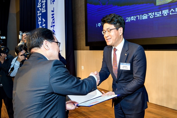 ▲ SK텔레콤 박진효 네트워크기술원장(오른쪽)이 유영민 과학기술정보통신부장관으로부터 대통령상을 받고 있는 모습.ⓒSK텔레콤