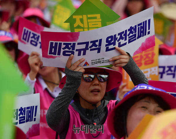 지난 6월30일 서울 광화문광장에서 열린 집회에서, 한 참석자가 비정규직 철폐를 요구하는 손피켓을 들고 있다. ⓒ 뉴데일리 정상윤 기자.