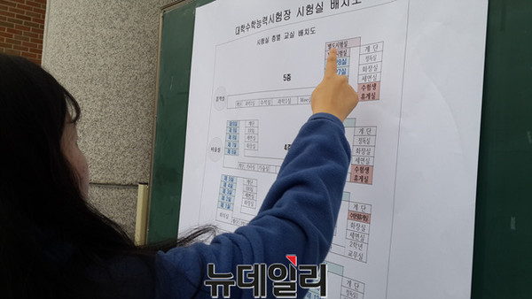 ▲ 22일 충북 청주시의 한 수능시험장교에서 수험생이 변경된 시험실 배치도를 확인하고 있다.ⓒ김종혁 기자