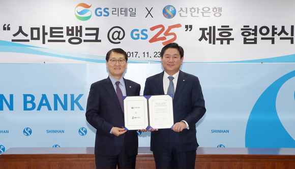 ▲ GS리테일과 신한은행은 새로운 비즈니스모델 발굴을 위한 ‘스마트뱅크 @GS25’ 업무협약을 체결했다. 23일 서울 중구 소재 신한은행 본점에서 진행된 협약식에서 GS리테일 허연수 대표이사(오른쪽)와 신한은행 위성호 은행장이 기념촬영하는 모습. ⓒGS25