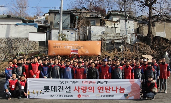 ▲ '사랑의 연탄 나눔' 봉사활동에 참여한 롯데건설 샤롯데 봉사단이 기념촬영을 하고 있다. ⓒ롯데건설