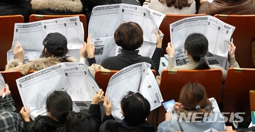 ▲ 지난 25일 서울 서초구 서초문화예술회관에서 열린 '2018 대입정시 설명회'에서 수험생, 학부모 등이 입시업체 정시 배치참고표를 살펴보고 있다. ⓒ뉴시스