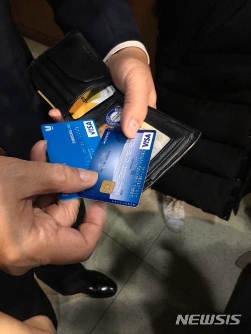 ▲ 법인카드 유흥주점 유용 의혹 등을 받고 있는 김경재 자유총연맹 총재가 지난 1일 서울 모처에서 강연을 마치고 나오는 길에 자신의 지갑 속 카드를 취재진에게 보여주고 있다.ⓒ사진=뉴시스.