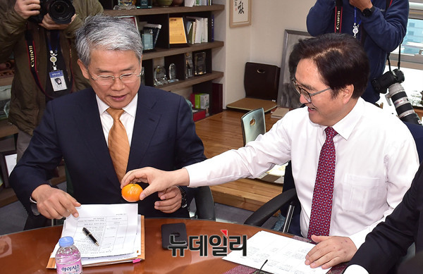 ▲ 더불어민주당 우원식 원내대표가 4일 오전 의원회관 자신의 사무실에서 국민의당 김동철 원내대표에게 미리 준비한 귤을 건네고 있다. ⓒ뉴데일리 이종현 기자