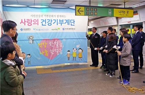 HUG를 비롯한 관계자들이 부산도시철도 1호선 남포역에서 HUG 사랑의 건강기부계단 제막식을 진행하고 있다. ⓒHUG