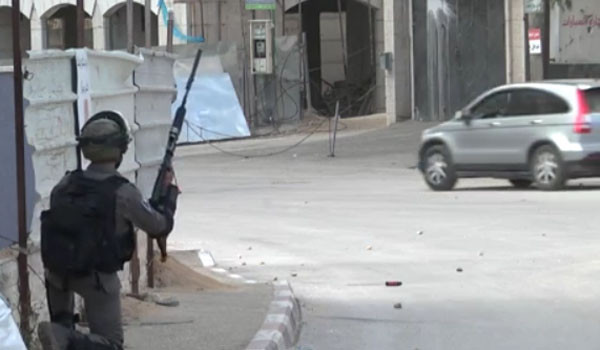 골목에 숨어 돌을 던지는 시위대를 향해 고무탄을 발사할 준비를 하는 이스라엘 방위군 병사. ⓒ타임 오브 이스라엘 관련보도 화면캡쳐.